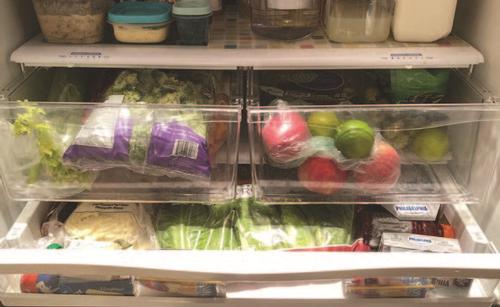 The inside of a refrigerator filled with fruit, vegetables, dairy, and leftovers. Photo by Sara Adlington